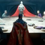 A round table surrounded by various figures, with a central figure draped in red fabric.